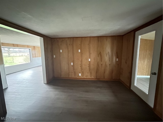 spare room with wood walls