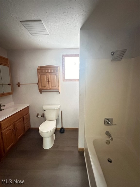 full bathroom featuring vanity, a textured ceiling, toilet, shower / bathing tub combination, and hardwood / wood-style flooring