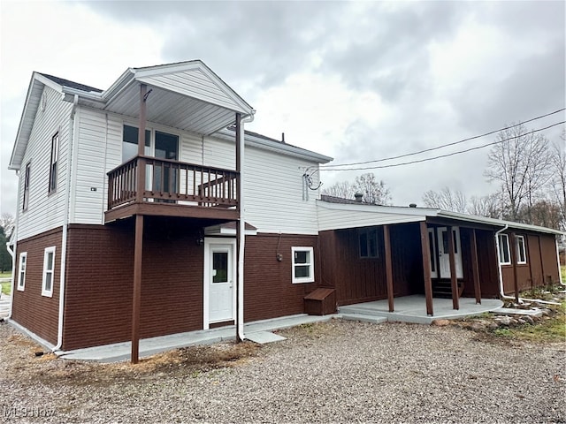 rear view of house featuring a balcony and a patio area