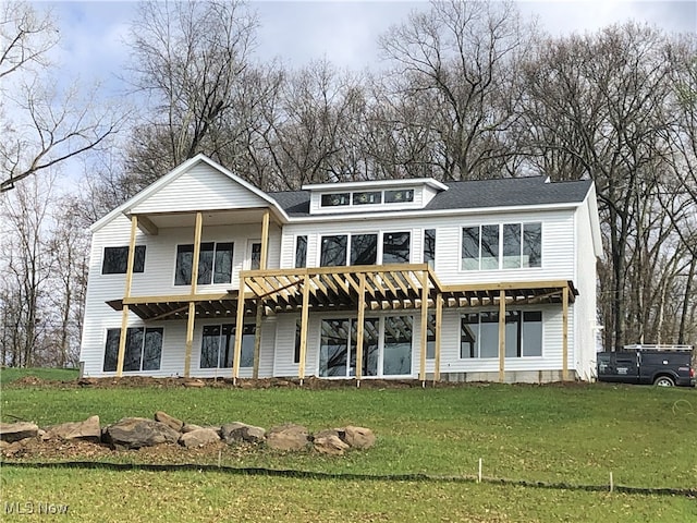 back of property with a pergola and a yard