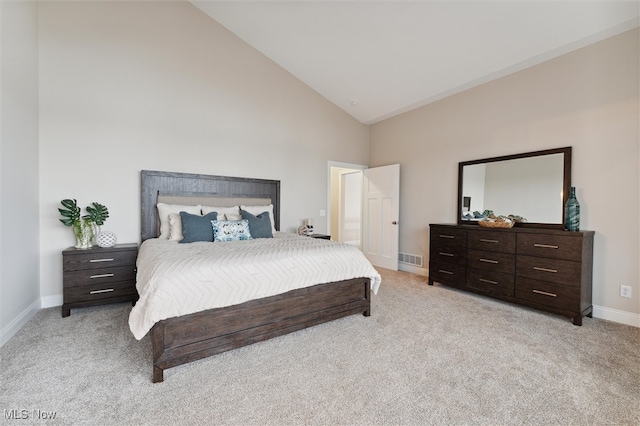 bedroom with light carpet and high vaulted ceiling