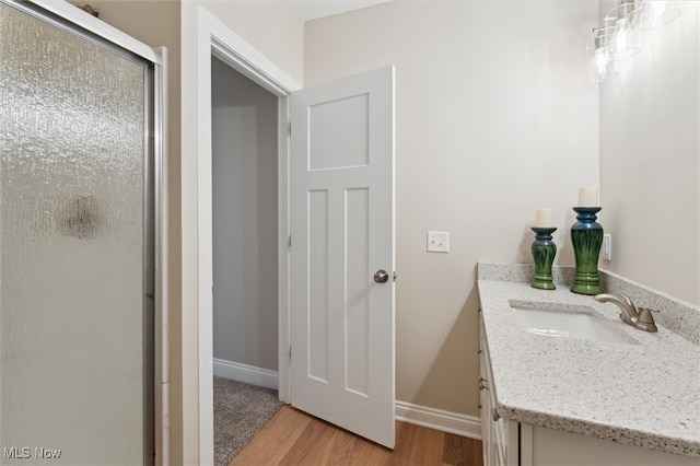 bathroom featuring wood-type flooring, vanity, and an enclosed shower