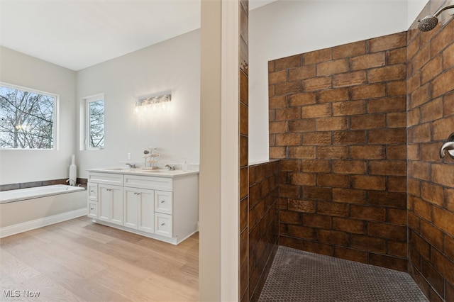 bathroom featuring vanity, wood-type flooring, and shower with separate bathtub