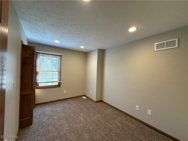 unfurnished room featuring carpet floors and a textured ceiling