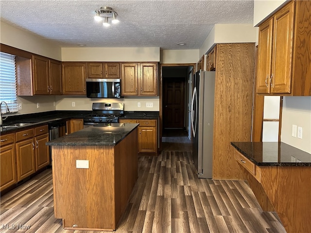 kitchen featuring dark hardwood / wood-style flooring, a center island, stainless steel appliances, and sink