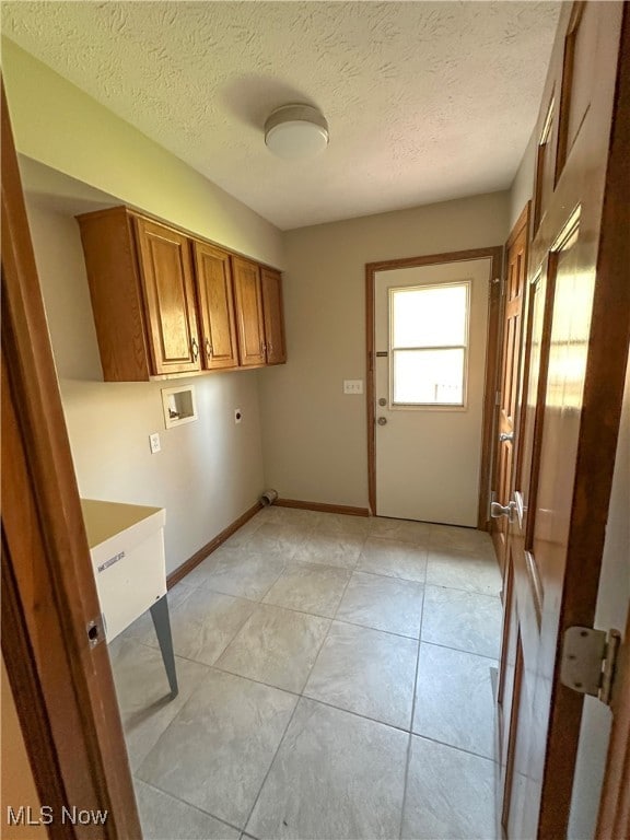 laundry area with cabinets, washer hookup, a textured ceiling, and hookup for an electric dryer