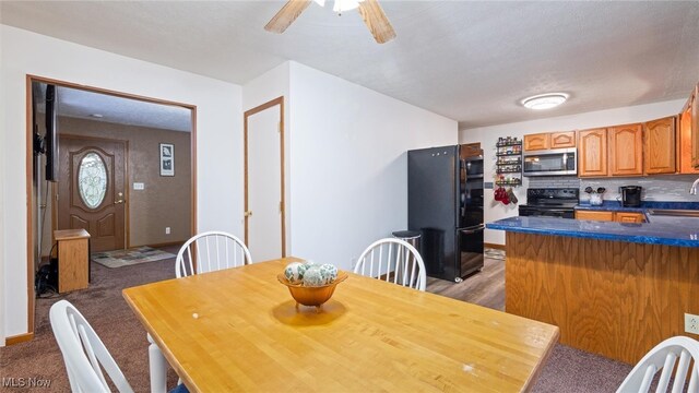 carpeted dining room with ceiling fan, sink, and a textured ceiling