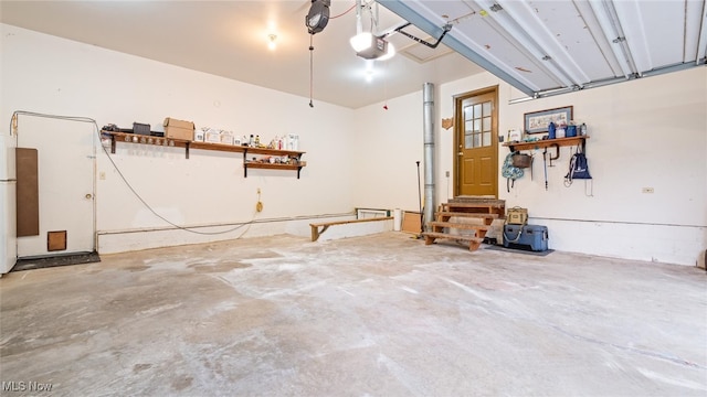 garage featuring white fridge and a garage door opener