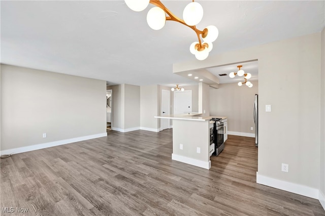 kitchen featuring a chandelier, decorative light fixtures, stainless steel appliances, and dark hardwood / wood-style floors