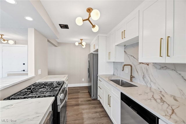 kitchen featuring light stone countertops, white cabinetry, sink, dark wood-type flooring, and appliances with stainless steel finishes