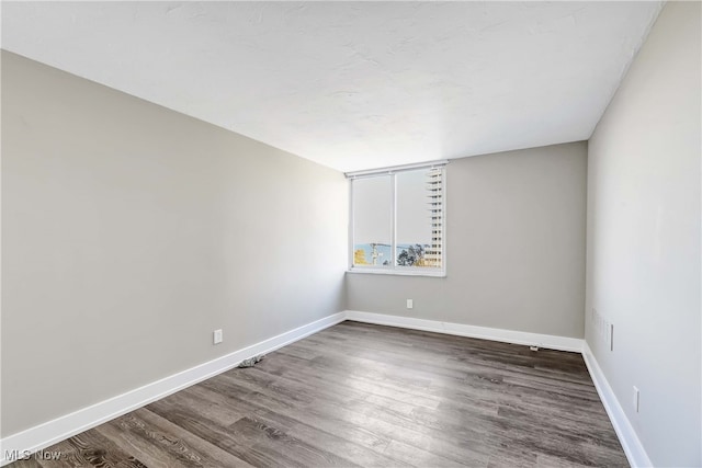 spare room featuring dark wood-type flooring