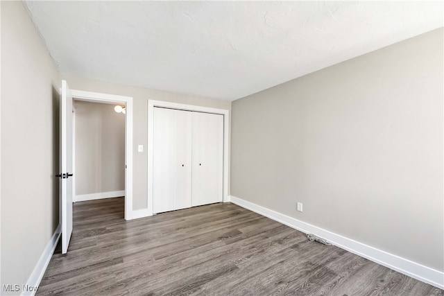 unfurnished bedroom featuring a closet and wood-type flooring