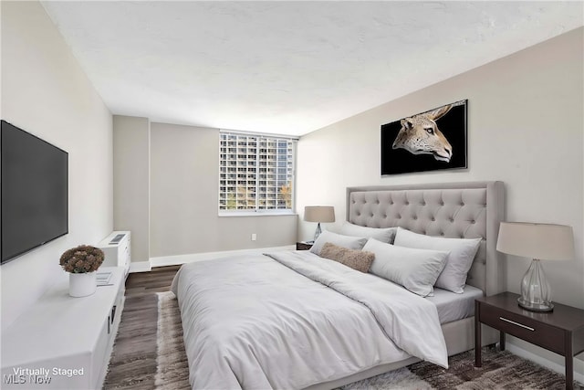 bedroom with dark wood-type flooring