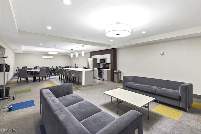 living room featuring a tray ceiling and sink