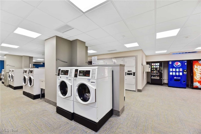 clothes washing area featuring light colored carpet and separate washer and dryer