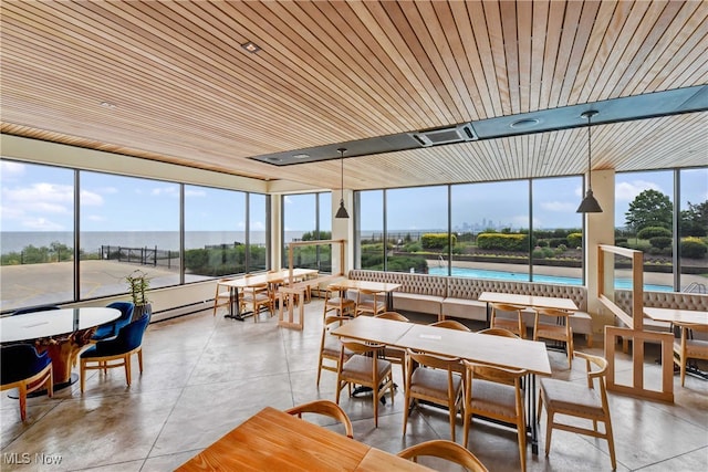 sunroom / solarium featuring plenty of natural light, a water view, and wood ceiling