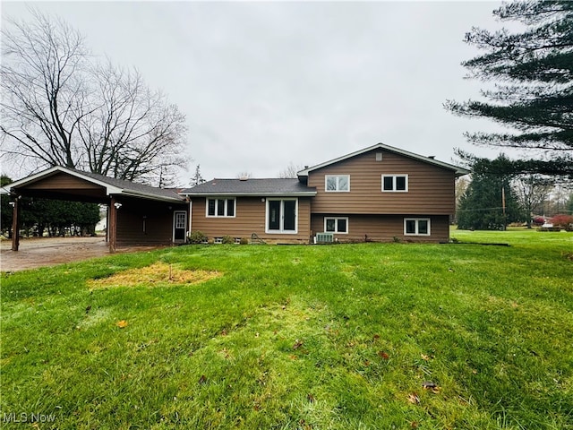 rear view of house with a yard, cooling unit, and a carport