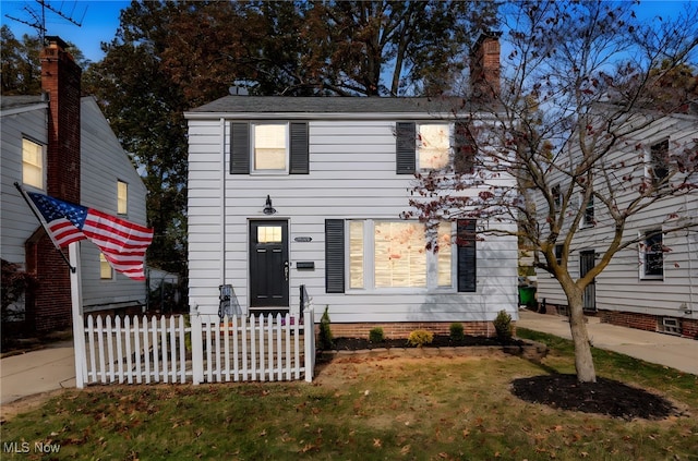 colonial-style house with a front lawn