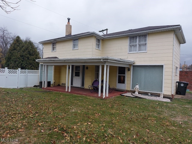 back of property with a yard and a patio