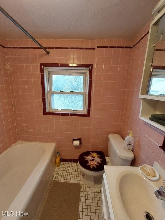 full bathroom with tile patterned flooring, a healthy amount of sunlight, and tile walls