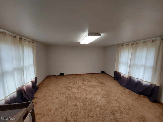 unfurnished room featuring light colored carpet