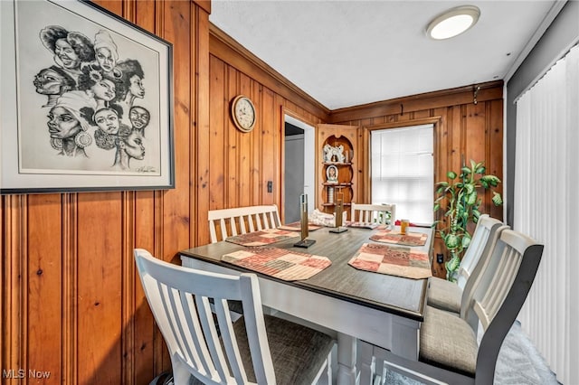 dining room with wood walls