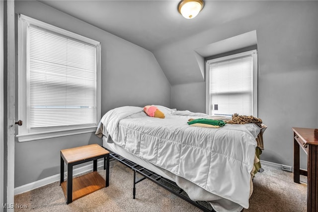 bedroom featuring carpet floors, multiple windows, and lofted ceiling