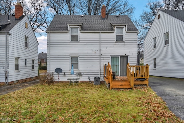 rear view of house with a yard and a wooden deck