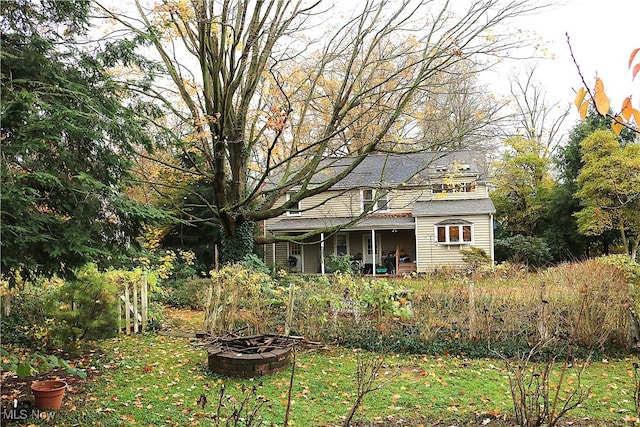 exterior space featuring a fire pit and a lawn