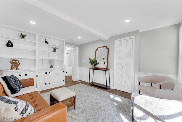 living room with beam ceiling and dark hardwood / wood-style flooring