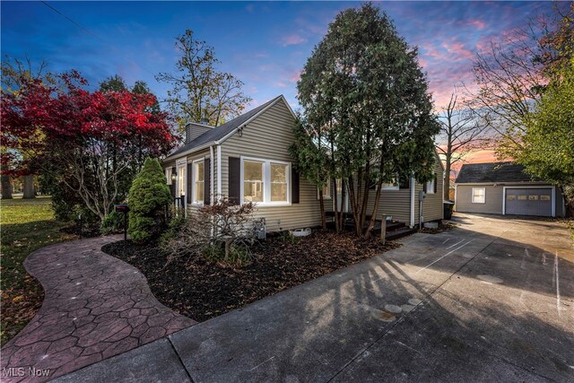 property exterior at dusk featuring an outdoor structure and a garage