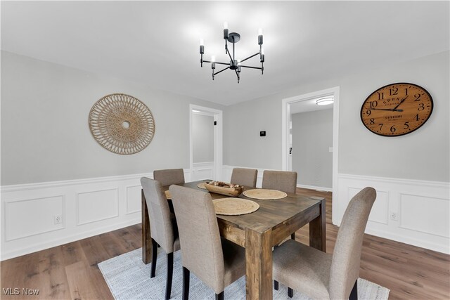 dining area featuring hardwood / wood-style flooring and a chandelier