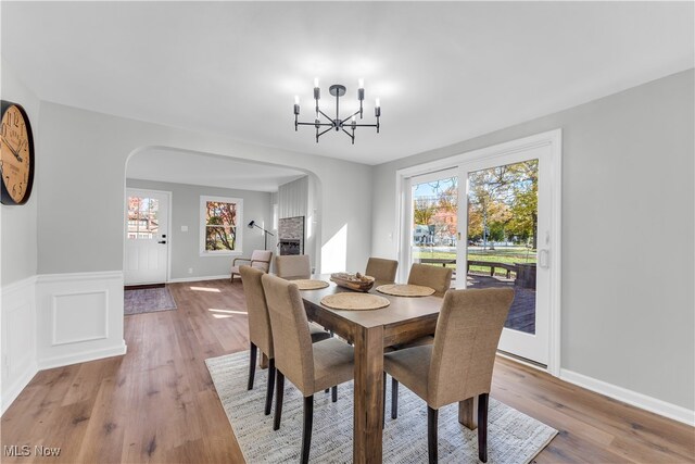 dining area with light hardwood / wood-style floors, an inviting chandelier, and plenty of natural light