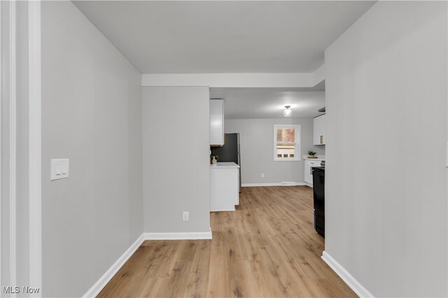 corridor with light hardwood / wood-style floors