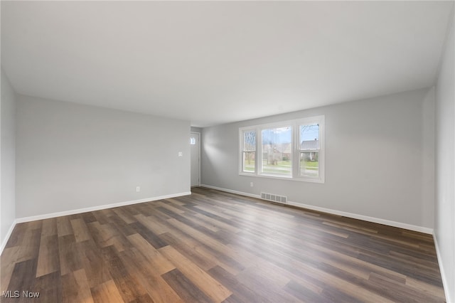 spare room with dark wood-type flooring