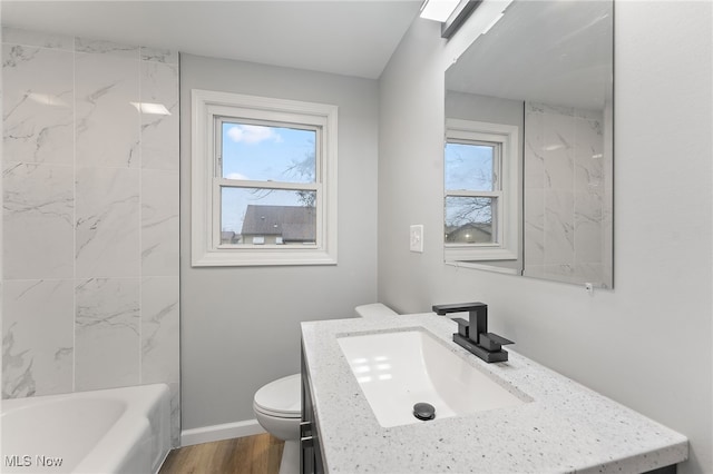 full bathroom featuring toilet, vanity, a healthy amount of sunlight, and wood-type flooring