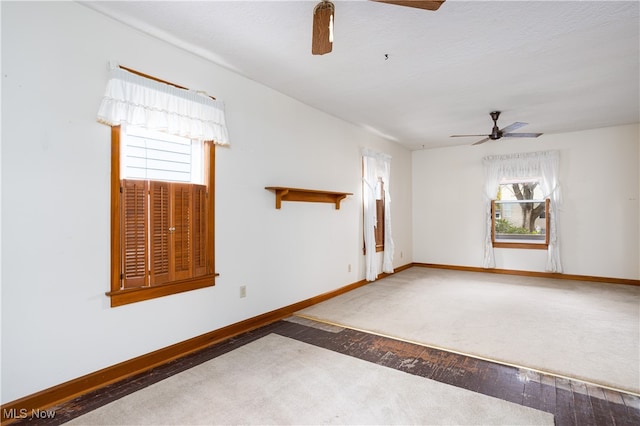 spare room with wood-type flooring, ceiling fan, and a healthy amount of sunlight