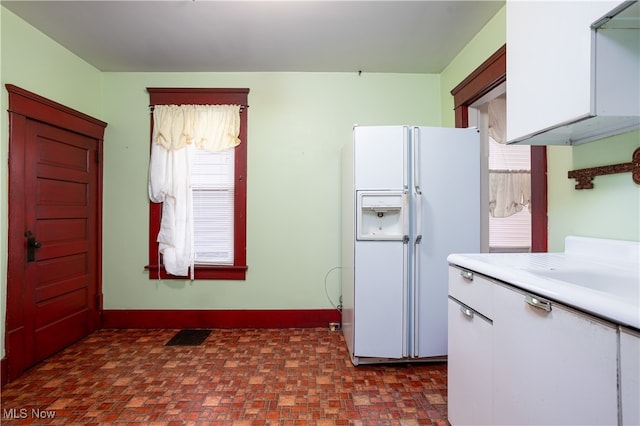 kitchen with white cabinets and white fridge with ice dispenser