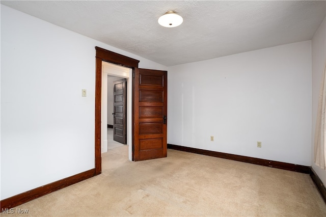 carpeted empty room featuring a textured ceiling