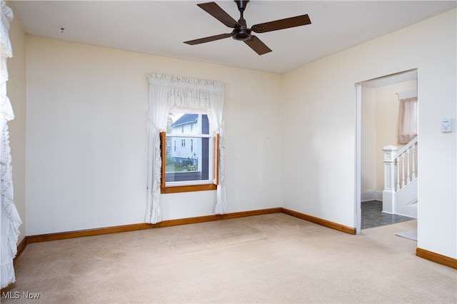 carpeted spare room with ceiling fan