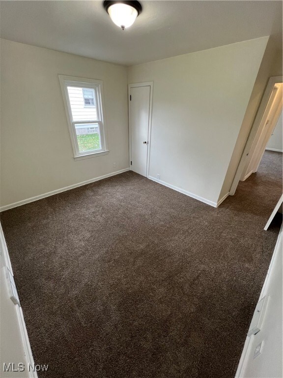 empty room featuring dark carpet