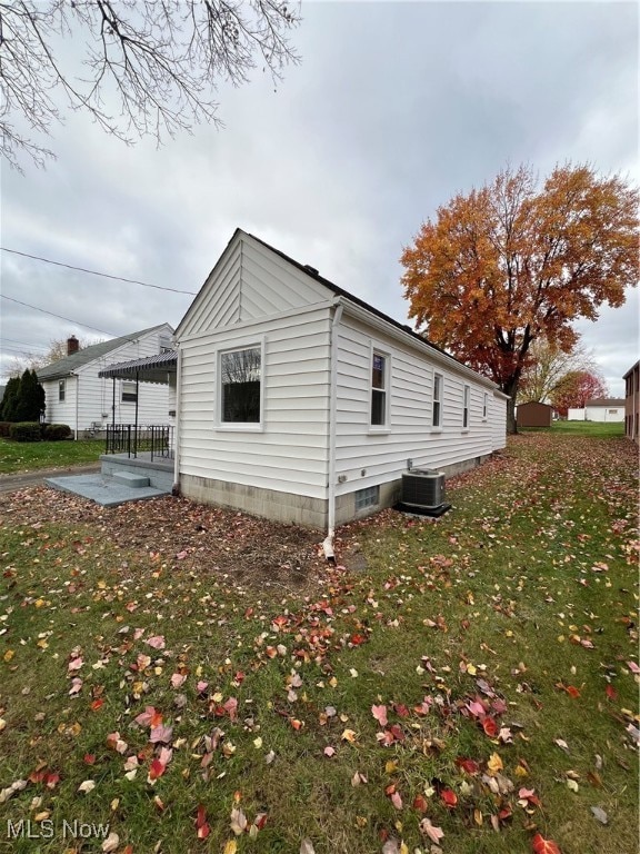 view of home's exterior featuring central air condition unit, a yard, and a patio