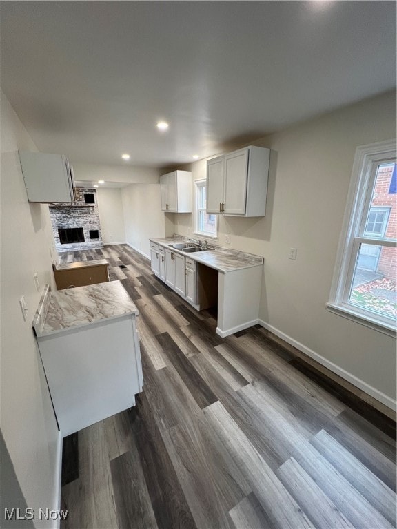 kitchen with dark hardwood / wood-style flooring, white cabinetry, and sink