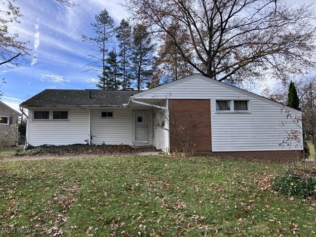 rear view of house featuring a lawn