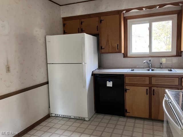 kitchen with dishwasher, white refrigerator, stainless steel range oven, and sink