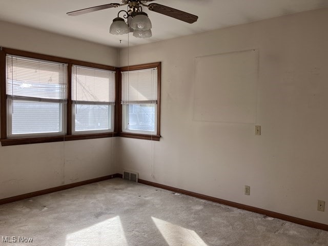 spare room featuring ceiling fan and light carpet