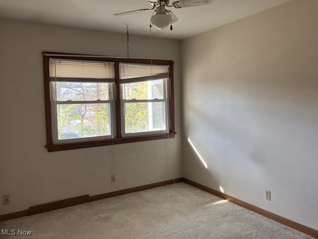 spare room with ceiling fan and light colored carpet