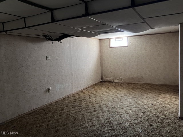 basement with carpet and a paneled ceiling