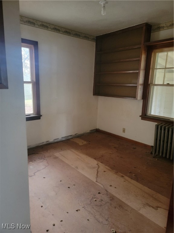 unfurnished room featuring radiator heating unit