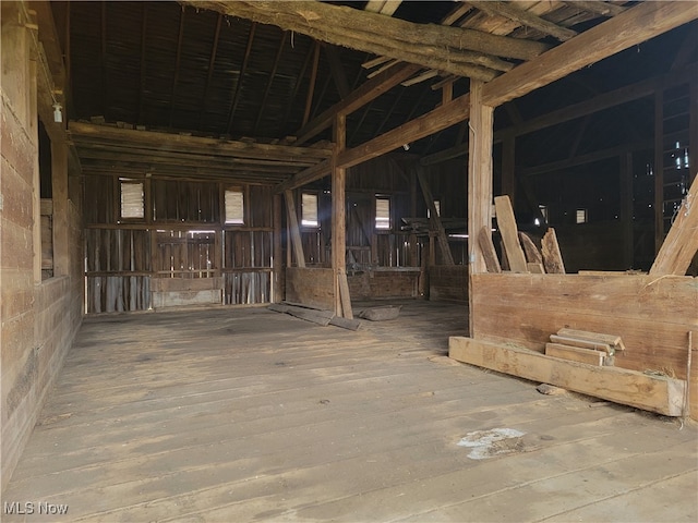 miscellaneous room featuring vaulted ceiling with beams and wood-type flooring